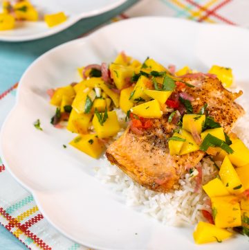 Plate of salmon topped with mango salsa.