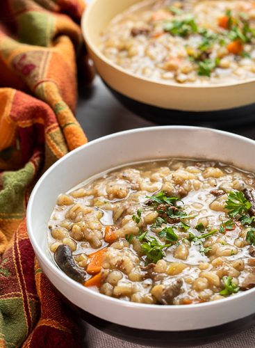Two bowls of beef barley and mushroom soup.