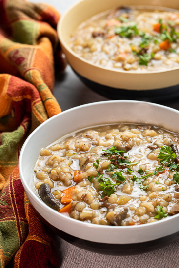 Two bowls of beef barley and mushroom soup.