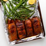 Glazed salmon on a foil lined baking sheet.