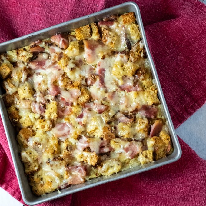 Savory bread pudding in a square pan.