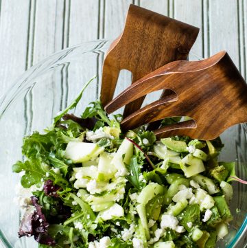 Bowl with Green Salad and wooden salad tossers.