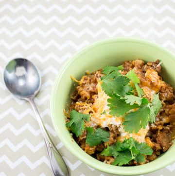 Bowl of chili topped with cheese and cilantro