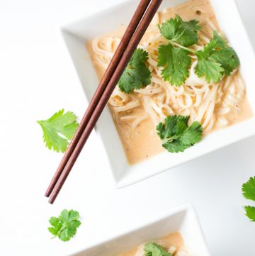 Two bowls of curried noodles.