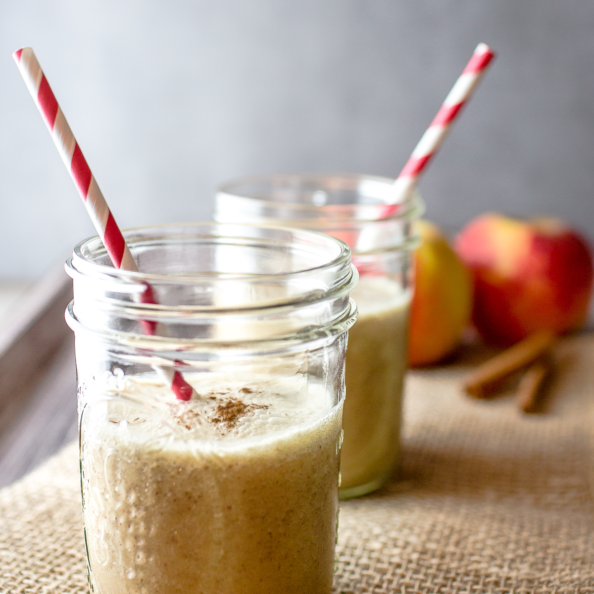 Two glass jars filled with apple smoothie