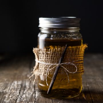 Jar of vanilla infused rum, with vanilla bean tied to it.