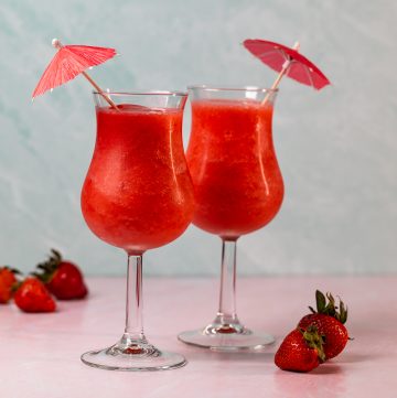 Two glasses filled with deep red frozen cocktails.