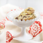 Cranberry biscotti in a ruffled white candy dish.