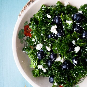 Bowl of kale salad with blueberries and feta cheese