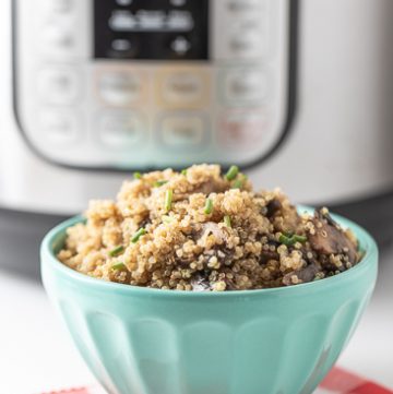Quinoa pilaf in a bowl in front of an instant pot.