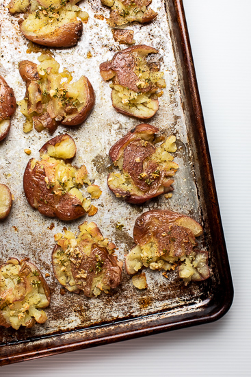 Smashed potatoes on a baking tray.