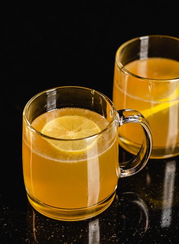 Two mugs filled with a hot toddy.