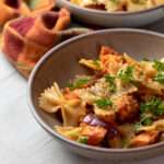 Bowl of pasta with sweet potatoes and bacon.