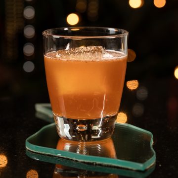 Orange cocktail with nutmeg grated on the top.