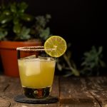 Margarita in a rocks glass with a salted rim and garnished with a lime wheel.