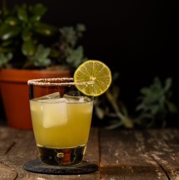 Margarita in a rocks glass with a salted rim and garnished with a lime wheel.