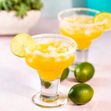 Bright orange mango margarita in a salt rimmed glass.