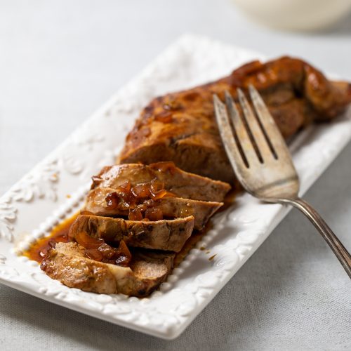 Pork tenderloin thinly sliced on a plate.
