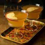 Two apple brandy sidecars on a vintage tray.