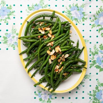 Platter of green beans with toasted almonds on top.