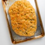 Focaccia bread on a cookie sheet.