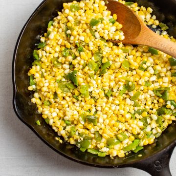 Cast iron skillet with corn and green peppers.