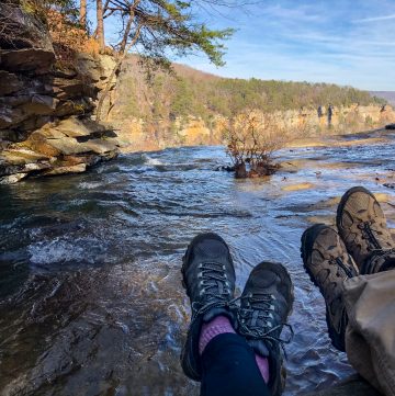 Two pairs of hiking boots on top of falling water falls.