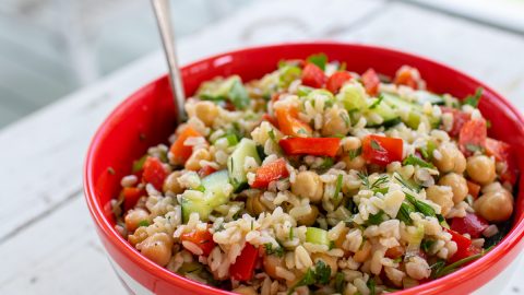 Red bowl filled with rice salad.