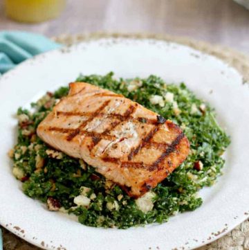 Grilled salmon resting atop a kale salad.