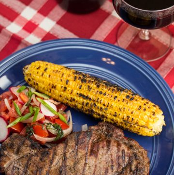 Plate with grilled steak and corn on the cob.