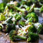 Close up of roasted broccoli on a baking sheet.