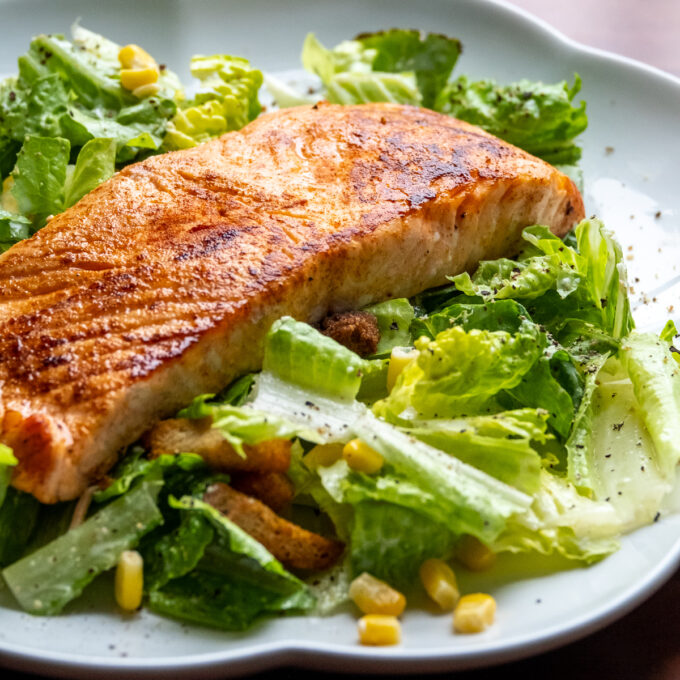 Seared salmon on a bed of romaine lettuce.
