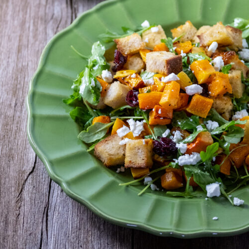 Close up of fall panzanella salad on a green plate.