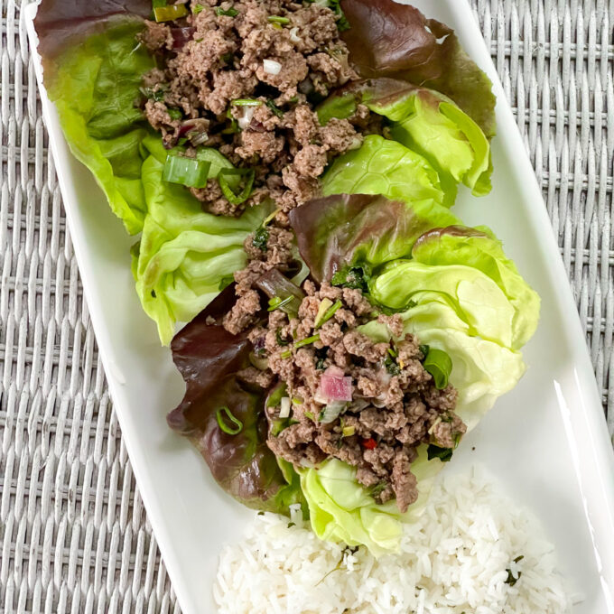 Close up of beef lettuce wraps on a white plate.
