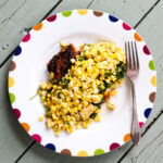 Salmon topped with corn salsa on a white plate.