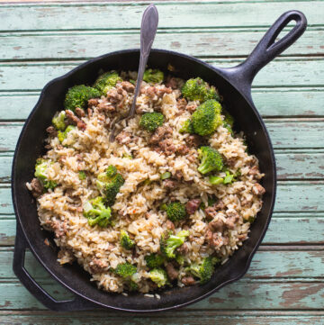 Sausage, rice and broccoli in a cast iron skillet.