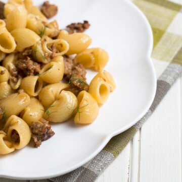 Close up of sausage and fennel pasta on a white plate.
