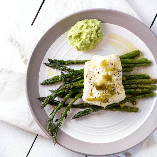 Cod and asparagus on a white and gray plate.