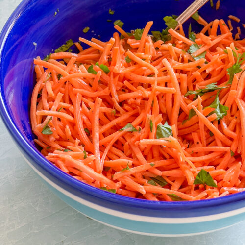 Carrot salad in a blue bowl.